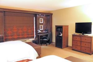 圣路易斯南圣路易斯55号洲际公路希尔顿恒庭旅馆&套房酒店的一间卧室配有一张床和一张书桌及电视