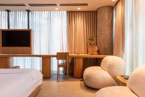 麦德林23 Hotel Medellin的一间卧室配有一张床和一张书桌及电视