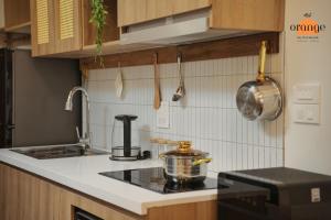 河内iRest Orange Tay Ho Lakeside Apartment的厨房配有炉灶和柜台上的锅