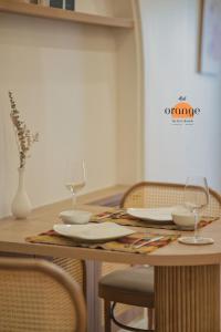 河内iRest Orange Tay Ho Lakeside Apartment的一张木桌,上面有两杯和盘子