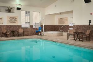 比尤特巴提希尔顿恒庭酒店的一个带椅子和桌子的游泳池以及浴缸