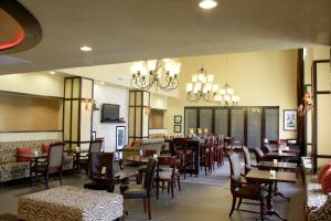 阿林顿达拉斯阿灵顿北部娱乐区汉普顿套房酒店 的用餐室配有桌椅和吊灯。