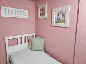 萨尔布吕肯萨吕度假屋酒店的一间卧室配有一张床和粉红色的墙壁