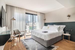 特拉维夫Jo Shtibel Tel-Aviv的酒店客房设有一张床和一个大窗户