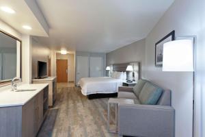 贺茂沙海滩赫莫萨比奇汉普顿套房酒店的大型酒店客房,配有床和沙发