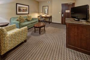 塔尔萨塔尔萨市中心希尔顿花园酒店的一间配备有沙发及平面电视的酒店客房