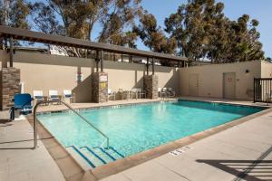 雷德兰兹Home2 Suites By Hilton Redlands的一个带桌椅的度假村游泳池