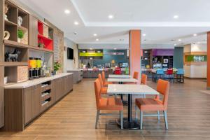 雷德兰兹Home2 Suites By Hilton Redlands的一间设有桌椅和厨房的自助餐厅