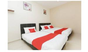 小笨珍Semerah Suites Homestay的一间卧室配有两张红色和白色床单