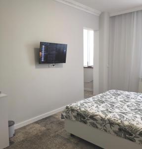 尼古拉耶夫Guest House in Mykolaiv的卧室配有一张床和壁挂式平面电视。
