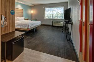 罗阿诺Tru By Hilton Roanoke Hollins的酒店客房,配有床和电视