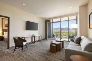 斯科茨Hilton North Scottsdale At Cavasson的酒店客房设有沙发、书桌和床。