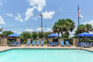 比洛克西Hampton Inn Biloxi-Ocean Springs的一个带椅子和遮阳伞的游泳池