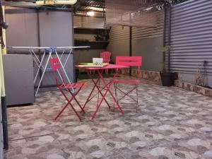 圣丹尼斯Studio avec grande terrasse的客房内的2把粉红色椅子和1张桌子