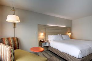 盖尔斯堡盖尔斯堡假日酒店的配有一张床和一把椅子的酒店客房