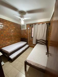 格拉瓦塔Casa Paraíso的一间卧室设有两张床和砖墙