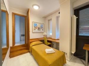 米兰笛费欧里酒店的一间卧室配有一张床、一张书桌和一个窗户。