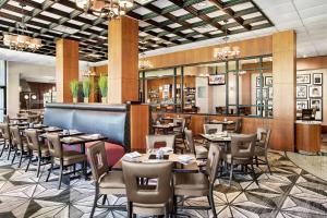 休斯顿休斯敦大学希尔顿酒店的一间带桌椅的餐厅和一间酒吧
