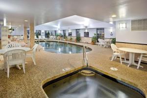 斯特布里奇斯特布里奇希尔顿恒庭酒店的游泳池位于带桌椅的房间中间