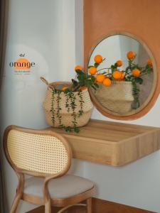河内iRest Orange Tay Ho Lakeside Apartment的架子上的镜子,椅子和橙子篮
