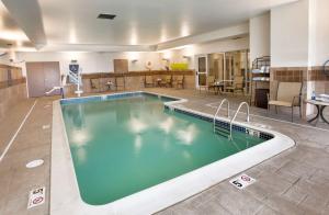 米德尔敦纽波特米德尔敦希尔顿霍姆伍德套房酒店的游泳池位于酒店带桌椅的客房内
