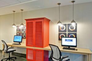 梅里迪恩Home2 Suites By Hilton Meridian的一间办公室,配有红色橱柜和一张桌子及两台电脑