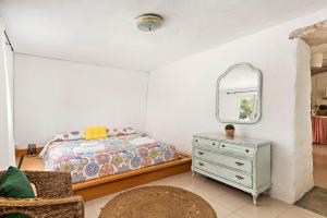 埃斯卡斯特利Casita Estancia d'en Carretero- Biniarroca的一间卧室配有床、镜子和梳妆台