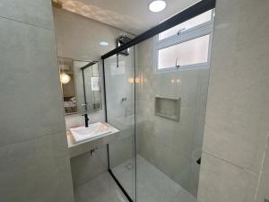 瓜鲁雅Refúgio Costeiro的一间带玻璃淋浴间和水槽的浴室