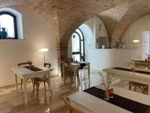 坎波马里诺Nina e il mare的一间设有桌椅的用餐室和砖墙