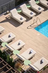 巴塞罗那加泰罗尼亚兰布拉大道酒店的一组躺椅,位于游泳池旁