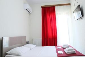 库塔伊西Hotel West Face的一间卧室配有一张带红色窗帘的床