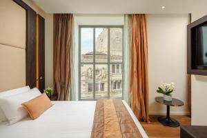 米兰Hotel Dei Cavalieri Milano Duomo的一间卧室设有一张床和一个大窗户
