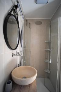 曼弗雷多尼亚Adelmarì Casa Vacanze的浴室配有盥洗盆和带镜子的淋浴