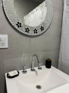 拉斐拉Casa Valentino的浴室水槽和墙上的镜子