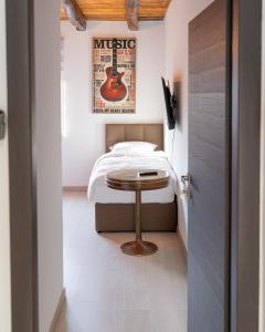 萨格勒布Arena Rooms Zagreb的卧室配有一张壁挂吉他的床