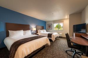 科罗拉多斯普林斯My Place Hotel-Colorado Springs,CO的酒店客房设有两张床、一张桌子和一台电视。