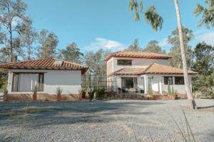 莱瓦镇Casa Dino en Villa de Leyva的前面有棕榈树的房子