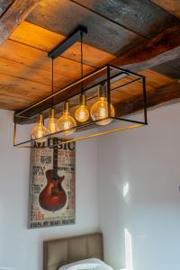 萨格勒布Arena Rooms Zagreb的挂在天花板上的吊灯,墙上挂着吉他