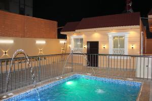 阿哈达شاليهات التميز الراقي的一座房子前面带喷泉的游泳池
