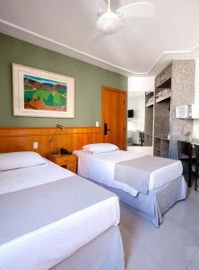 贝洛奥里藏特Savassinho Hotel & Residence的酒店客房带两张床和厨房