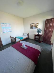 瓜拉派瑞Hope Hostel Guarapari的配有床和桌子、床和床的房间