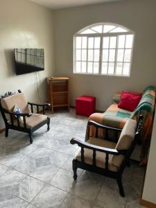 巴西利亚Hospedaria Chaves的客厅配有两张床和椅子