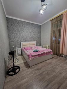 茨卡尔图博Magdan house的一间卧室配有一张带粉红色棉被的床