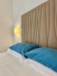 蒙特罗索阿尔马雷艾尔伯格德洋米奇酒店的一张带两个蓝色枕头和床头板的床