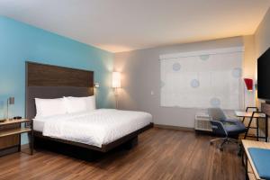 阿什兰Tru By Hilton Ashland, Va的酒店客房配有一张床、一张桌子和一把椅子。