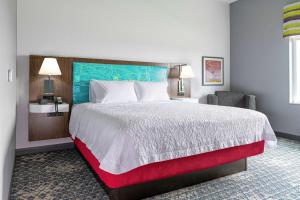 新斯坦顿Hampton Inn & Suites Pittsburgh New Stanton PA的酒店客房带一张大床和一把椅子