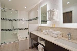 拉伯克Hampton Inn & Suites Lubbock University, Tx的一间带两个水槽和玻璃淋浴间的浴室