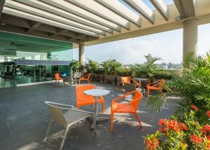 巴兰基亚巴兰基亚希尔顿汉普顿酒店的一座庭院,里面设有橙色的椅子和桌子