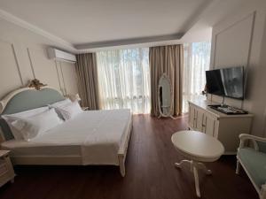 都拉斯SOL INVICTUS Boutique Hotel Durres Albania的酒店客房设有一张大床和一台电视。