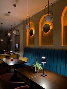 苏博蒂察AVIOR Garni Hotel的餐厅设有蓝色的沙发和桌子